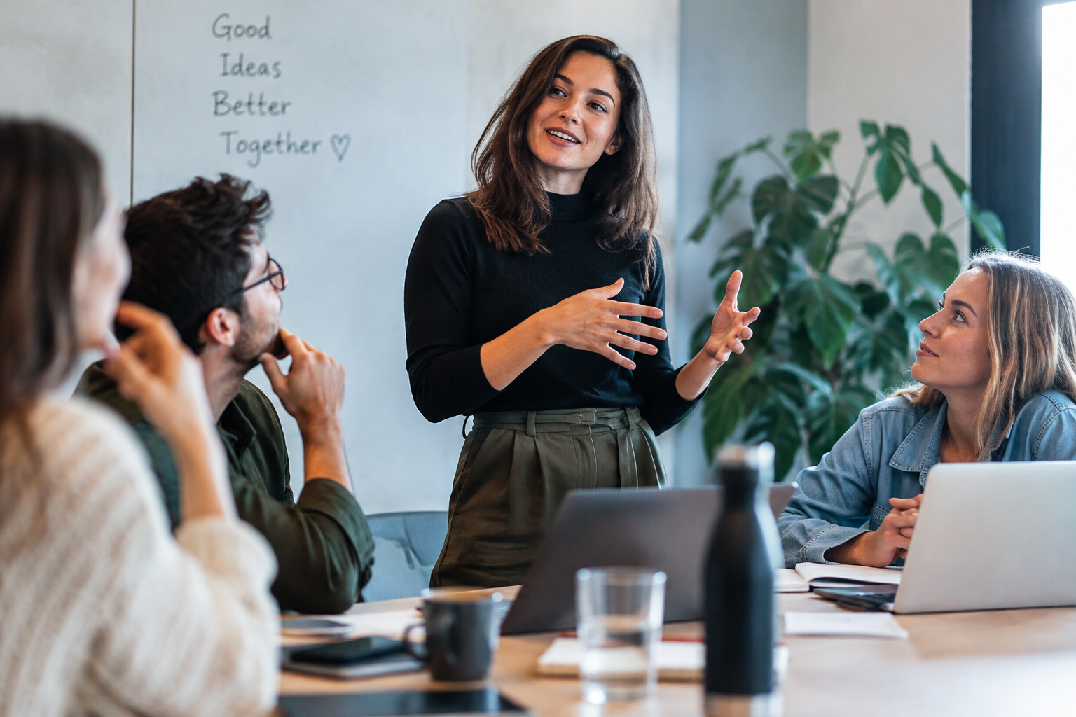 Trainer staat zelfverzekerd voor een groep professionals tijdens een sessie
